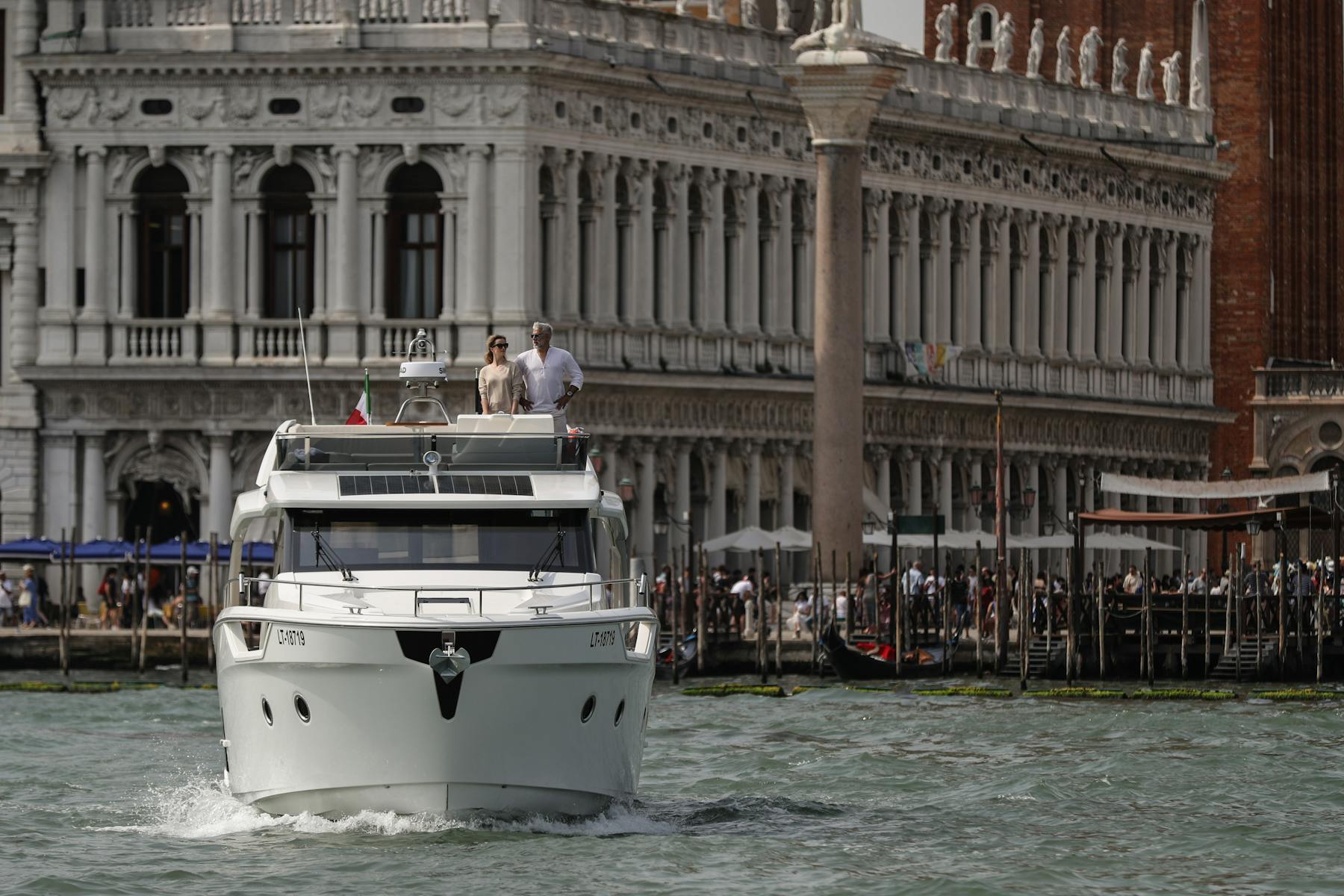 People aboard the Greenline 45 Fly beside Venetian waterfront buildings